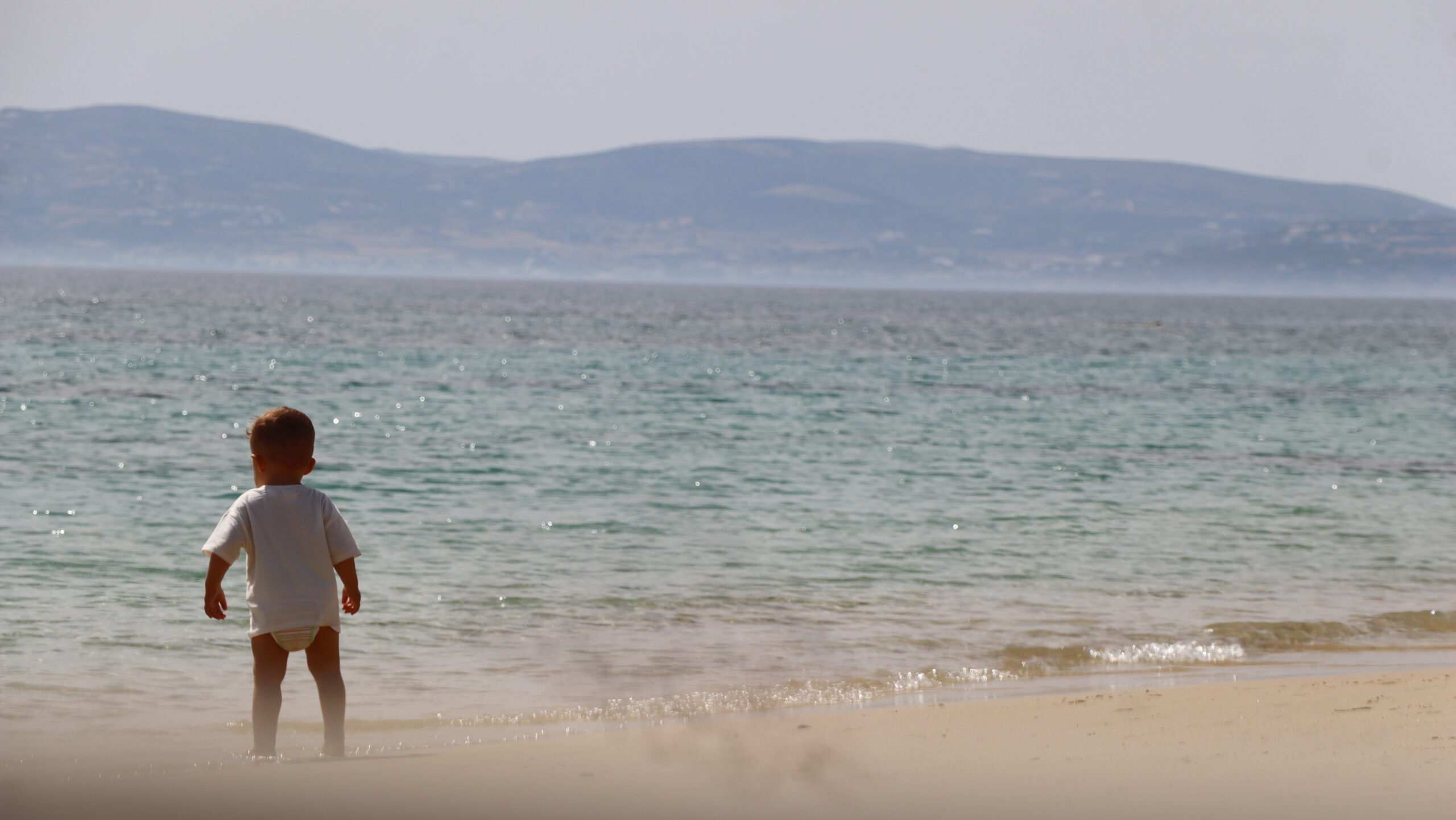 Fotografía de un bebé corriendo en la playa.